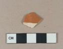 Factory decorated orange slipped refined earthenware body sherd