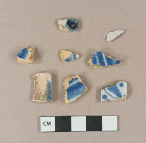 Blue hand painted tin glaze earthenware body sherds; polychrome hand painted tin glaze earthenware body sherd; undecorated tin glaze earthenware body sherd; tin glaze earthenware body sherd, missing all glaze; blue hand painted tin glaze fragment; three sherds crossmend