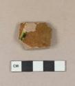 Brown lead glazed redware vessel body fragment, yellow slip decoration with blue splotches