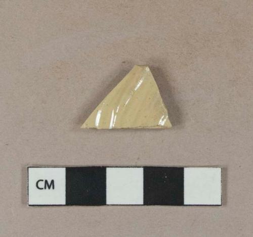 Buff-bodied stoneware body sherd, one side white-glazed, one side molded and buff-glazed