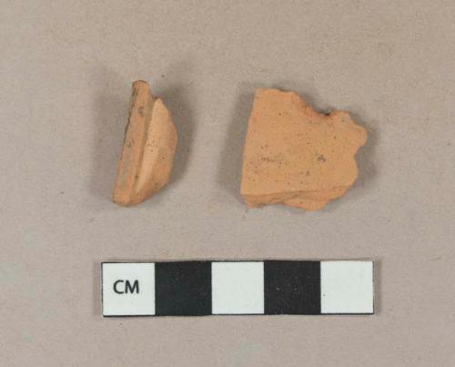 Undecorated unglazed redware vessel body and rim fragments