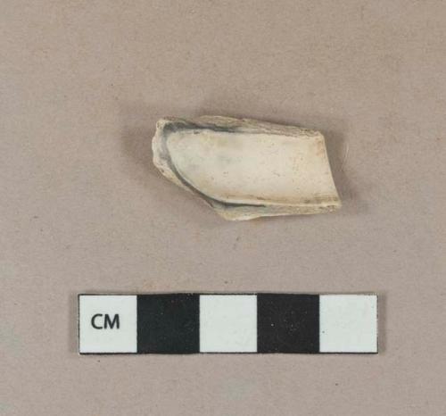 White undecorated kaolin pipe bowl fragment, burned