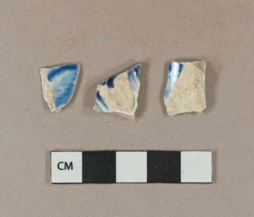 Blue on white transferprinted pearlware vessel body and base fragments, white paste; 1 blue on white handpainted shell-edged pearlware vessel rim fragment, white paste