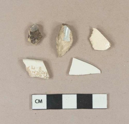 White undecorated pearlware vessel fragment; 3 undecorated creamware vessel fragments, 2 body fragments, 1 rim fragment; 1 stone fragment