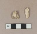 Undecorated buff kaolin pipe bowl fragments, 1 with cartouche fragment