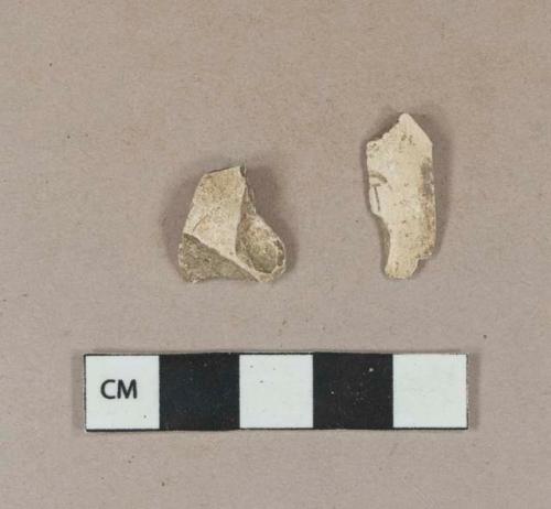 Undecorated buff kaolin pipe bowl fragments, 1 with cartouche fragment