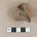 Brown lead glazed redware vessel base foot fragment, black paste at center, likely pipkin foot