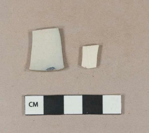 White salt glazed stoneware rim sherd with possible blue decoration; white salt glazed stoneware body sherd with incised line