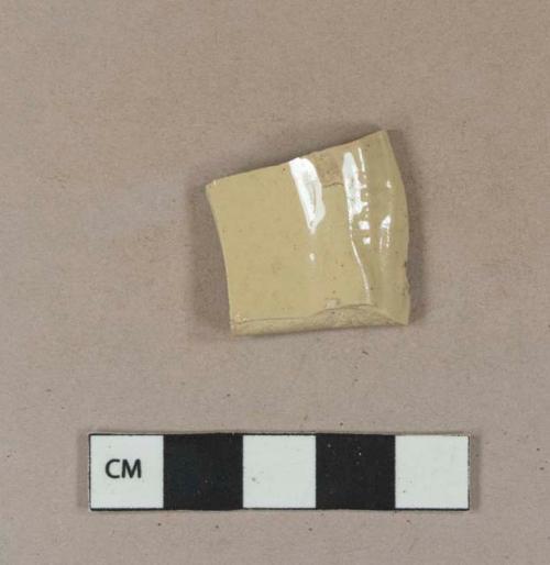 Buff-bodied stoneware rim sherd with on side white glazed and one side yellow glazed with molded rim