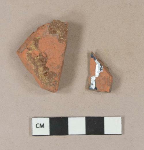 Undecorated lead glazed redware body sherd; slip decorated lead glazed redware body sherd