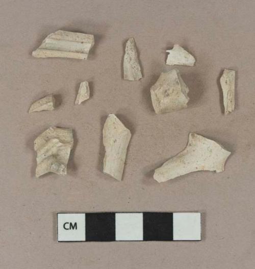 Smoked, undecorated pipe fragments, including bowl, heel, and stem. Some, likely all, fragments crossmend