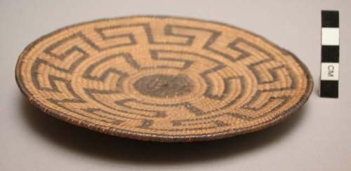 Basket, coiled. Geometric design, black on buff, black circle in center. 6.5"