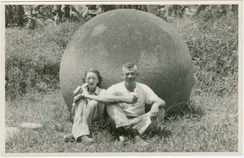 Dr. Doris Stone and Samuel K. Lothrop sitting against stone ball