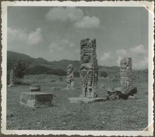 Upright stelae with stone objects in an open field
