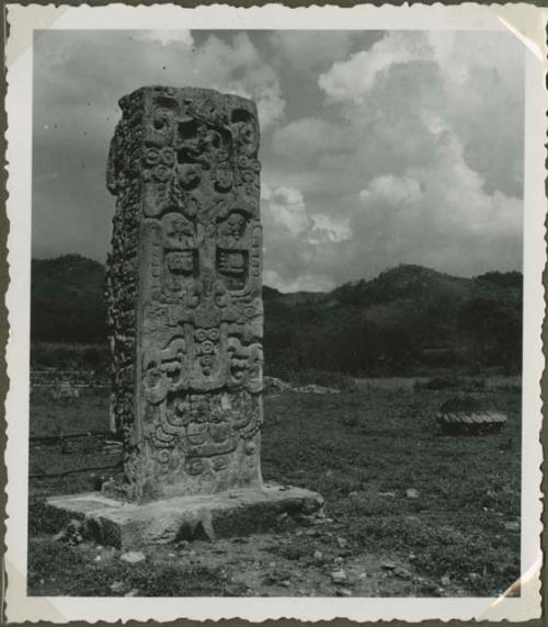 Upright stela in an open field