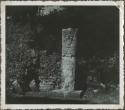 Upright stela in front of crumbling stone wall