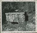 Flat stone sculpture in an overgrown field