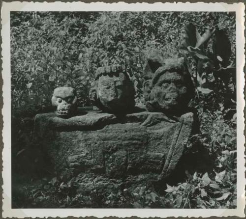 Stone sculpture in an overgrown field