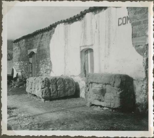 Large stone sculptures in front of a modern building