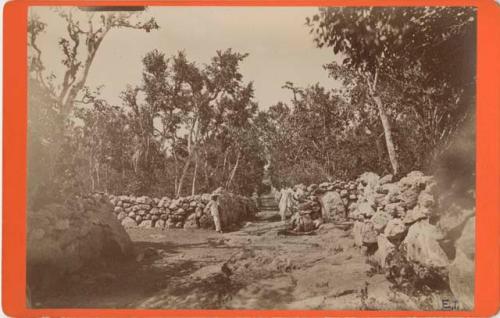 Stone walls and trees with two men