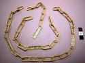 Ivory chains with oval bone pieces incised with black designs
