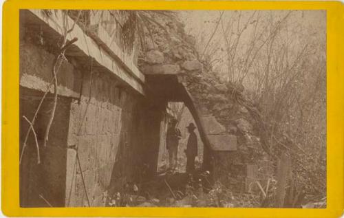 Two men under the vaulted arch of a stairway