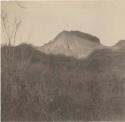 Landscape with butte in background