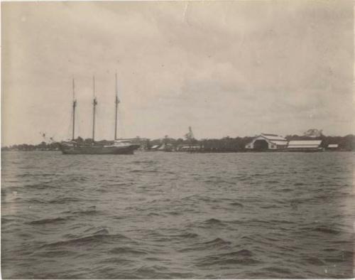 Three-masted ship on the water, coastline in background