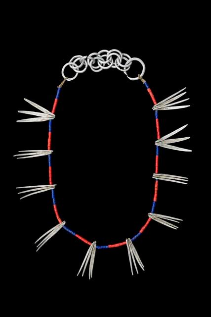 Necklace of glass beads and aluminum claws and rings