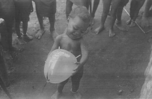 A young child, Padafan, with balloon, part of a behavior sequence  of photos