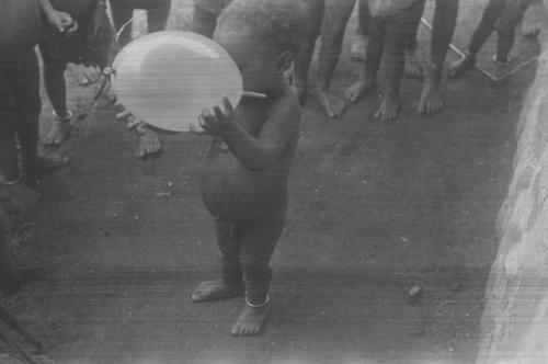 A young child, Padafan, trying to nurse a balloon, part of a behavior sequence  of photos