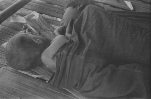 Wolmaoe and her little sister sleeping on the veranda in mid-morning