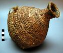 Small basketry water jug, twined. Made of bear grass. Pointed bottom.