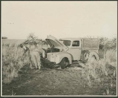 Men fixing an expedition truck (print is a cropped image)