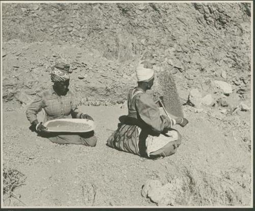 Two women sitting and mining by panning (print is a cropped image)