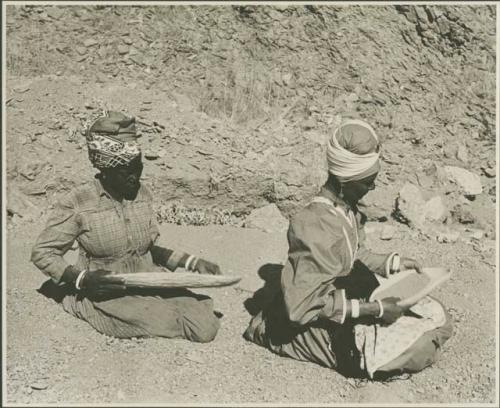 Two women sitting and mining by panning (print is a cropped image)