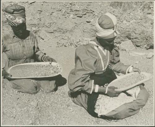 Two women sitting and mining by panning (print is a cropped image)