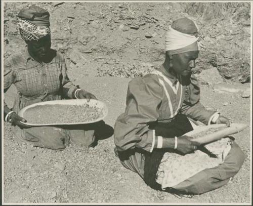 Two women sitting and mining by panning (print is a cropped image)