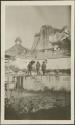 Three men standing on building ruins, possibly Antigua