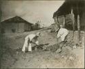 Two boys in hats shoveling in Copan