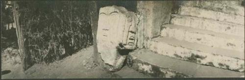 Broken stone sculpture leaning against stairs, Arevalo