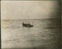 Men pushing small boat to shore in Tulum