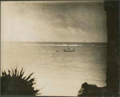 Through back window of Castillo, view of boat in the water, in Tulum