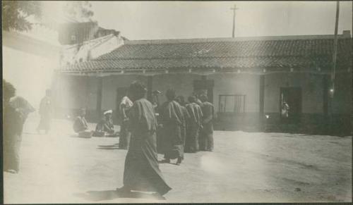 Group standing in street outside white building