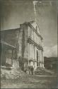 Man standing outside white building, possibly a church