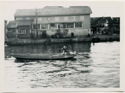 Boat in water, with building in background