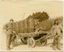 Two men and cart loaded with barrels