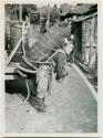 Man carrying barrel on his back