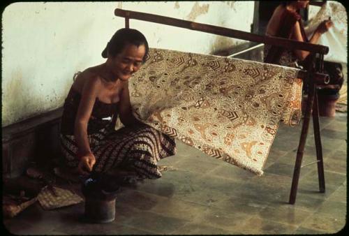 Court servant making batik