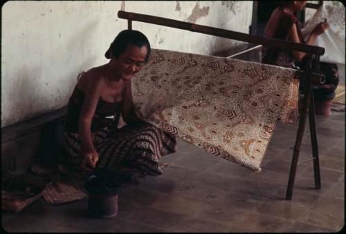 Court servant making batik